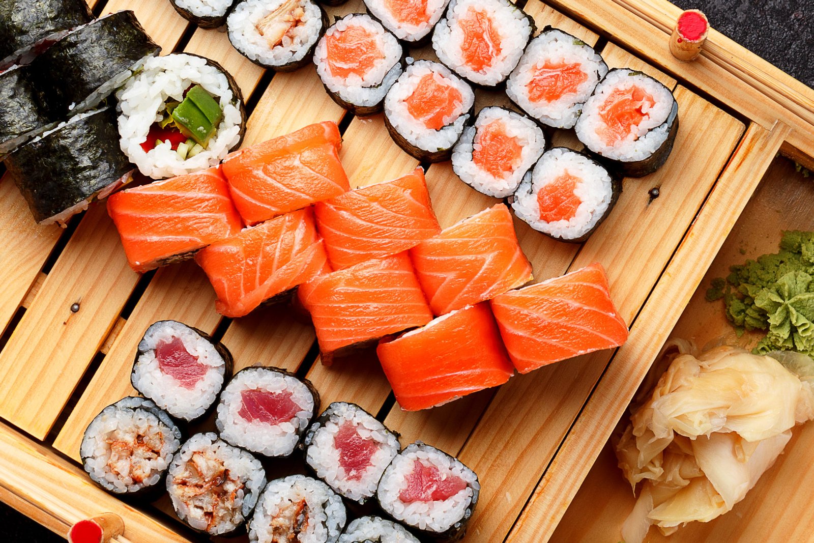 Sushi set on a wooden plate and dark concrete background. sushi