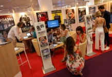 Cannes Market destaca filmes menores nas apostas Estande de cinema com cartazes de filmes.
