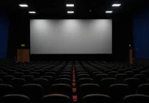 Os melhores filmes de 2026 até agora: 10 produções que estão dominando o cinema Sala de cinema vazia com tela apagada